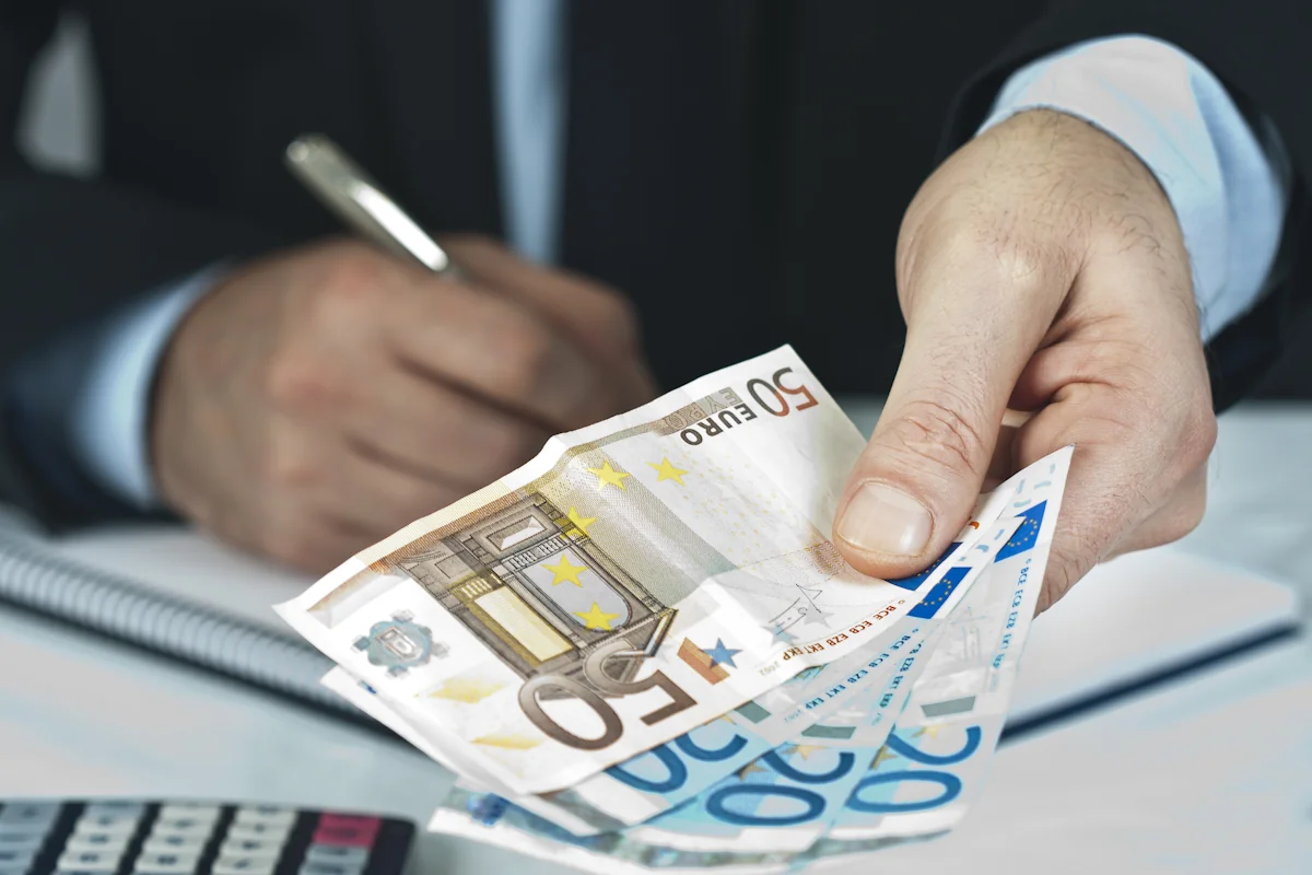 Une personne qui tend de l'argent en guise d'indemnités de servitude de ligne électrique